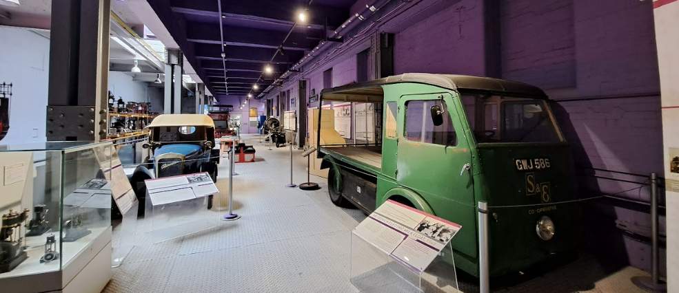 selection of old vehicles in kelham island museum - includes a milkfloat and car