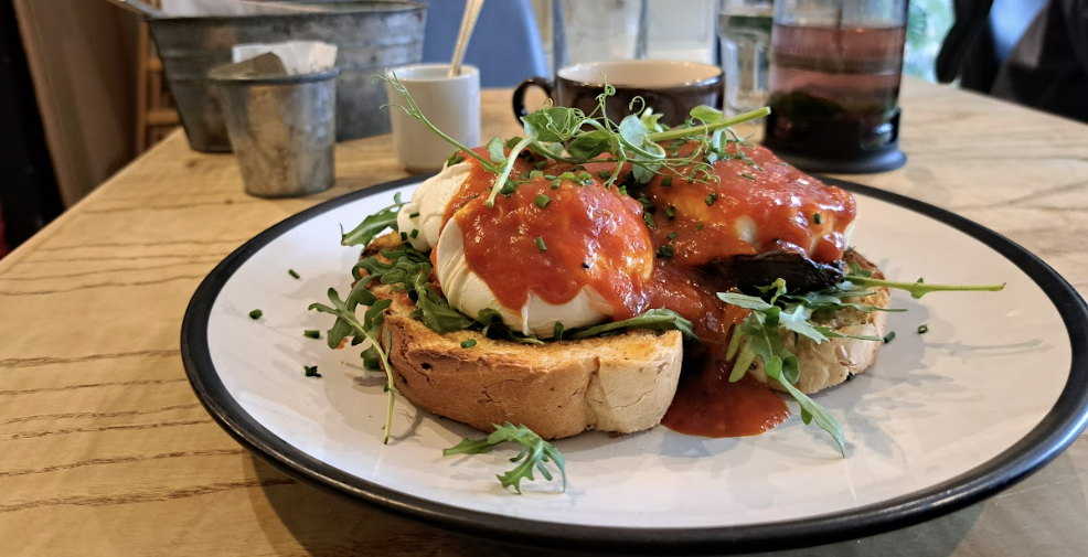 dish served at howst cafe - shows poached eggs on toast, covered in a tomato sauce