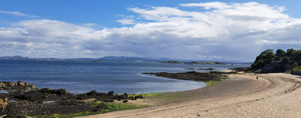 black sands, aberdour - edinburgh and arthurs seat are visible in the distance