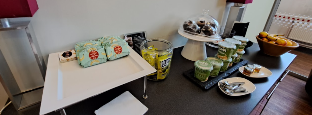 avanti first class lounge refreshments, showing cakes, olives, porridge, fruit and baked goods