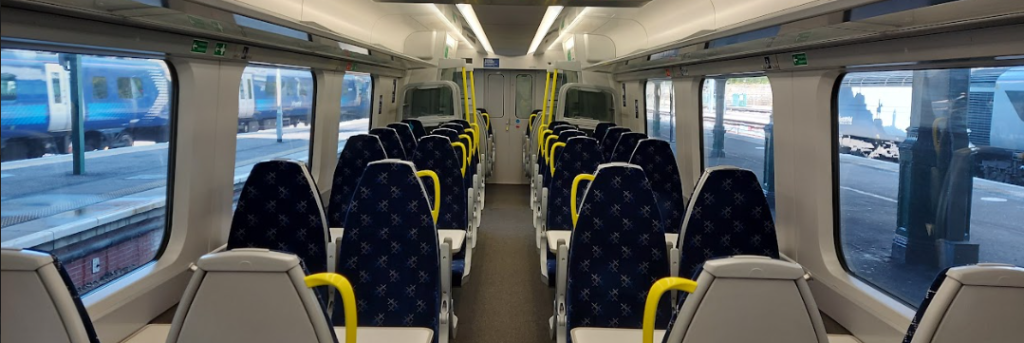 class interior showing a mix of tables and airline seats in standard class