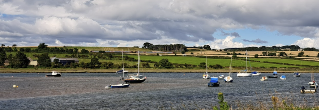 Alnmouth harbour, with a train passing in the background